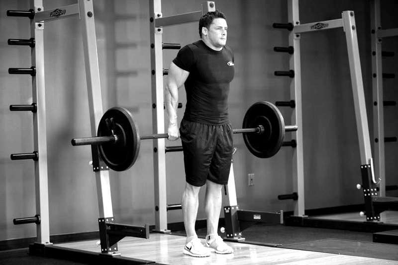 Barbell Shrug Behind The Back — end position demonstration photo
