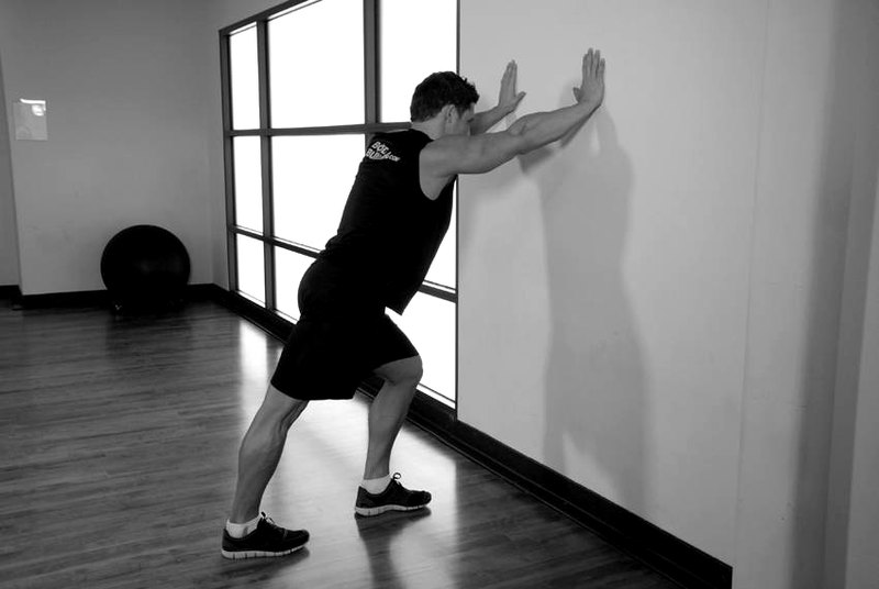 Calf Stretch Hands Against Wall — start position demonstration photo