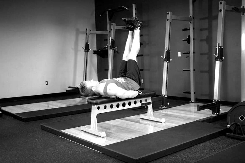 Flat Bench Lying Leg Raise — end position demonstration photo