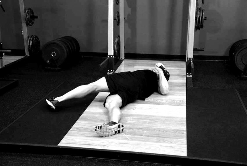 Leg-Over Floor Press — start position demonstration photo