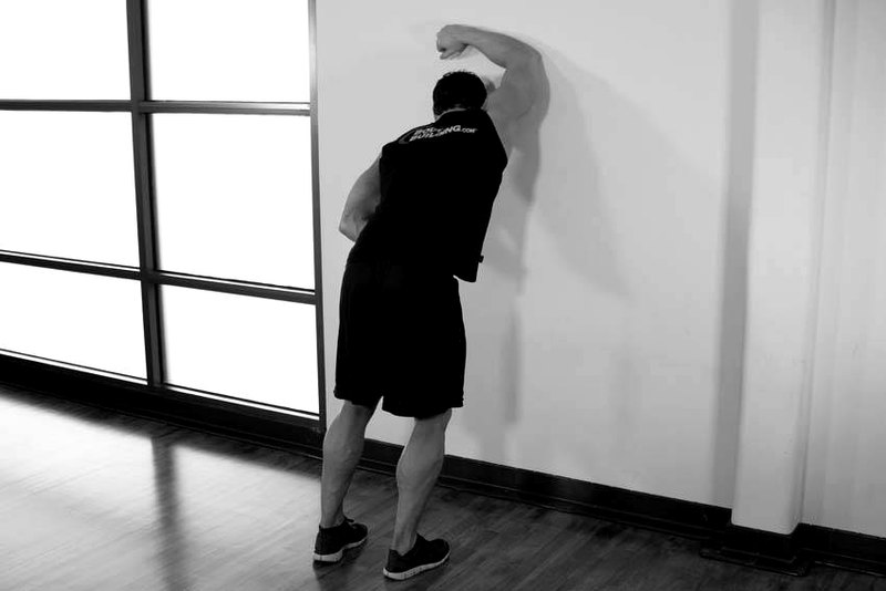 One Arm Against Wall — start position demonstration photo