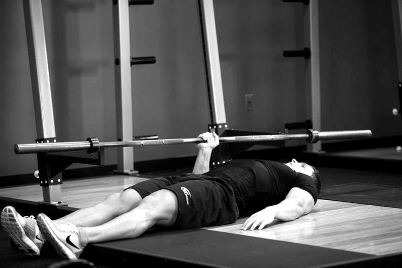 One Arm Floor Press — start position demonstration photo