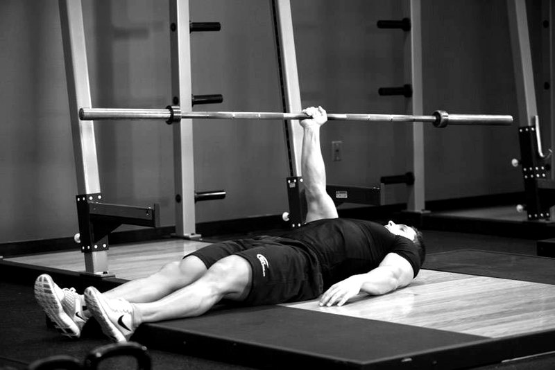 One Arm Floor Press — end position demonstration photo