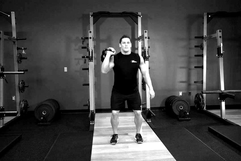 One-Arm Kettlebell Split Jerk — end position demonstration photo