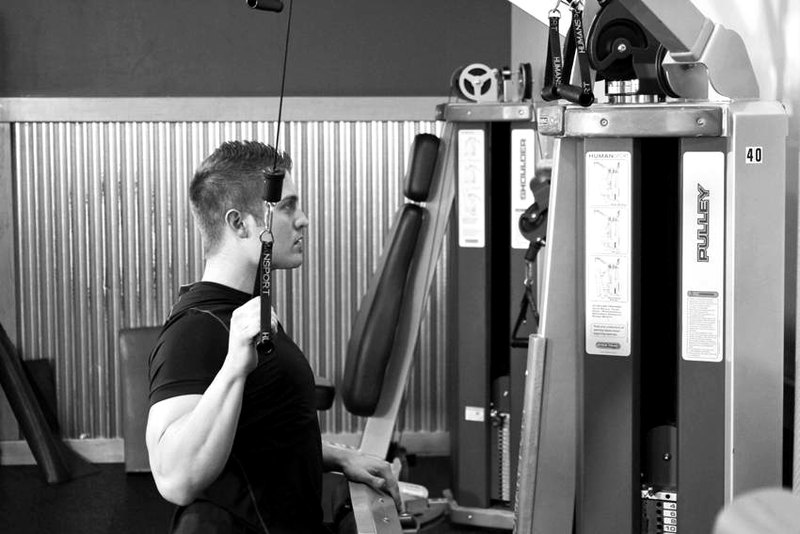 One Arm Lat Pulldown — end position demonstration photo