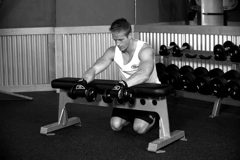 Palms-Down Dumbbell Wrist Curl Over A Bench — start position demonstration photo