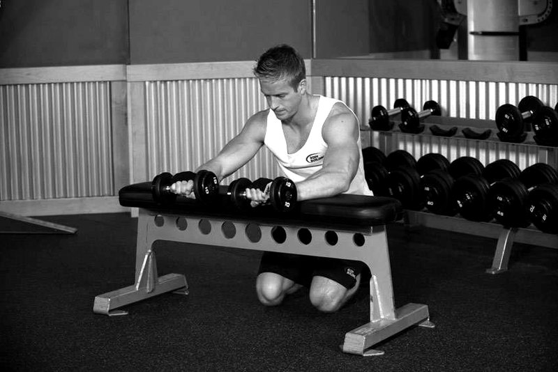 Palms-Down Dumbbell Wrist Curl Over A Bench — end position demonstration photo