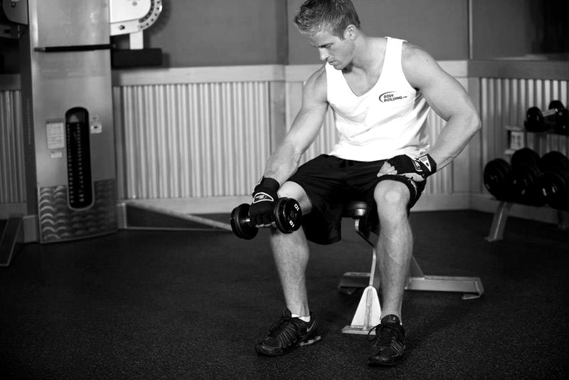Seated One-Arm Dumbbell Palms-Down Wrist Curl — start position demonstration photo