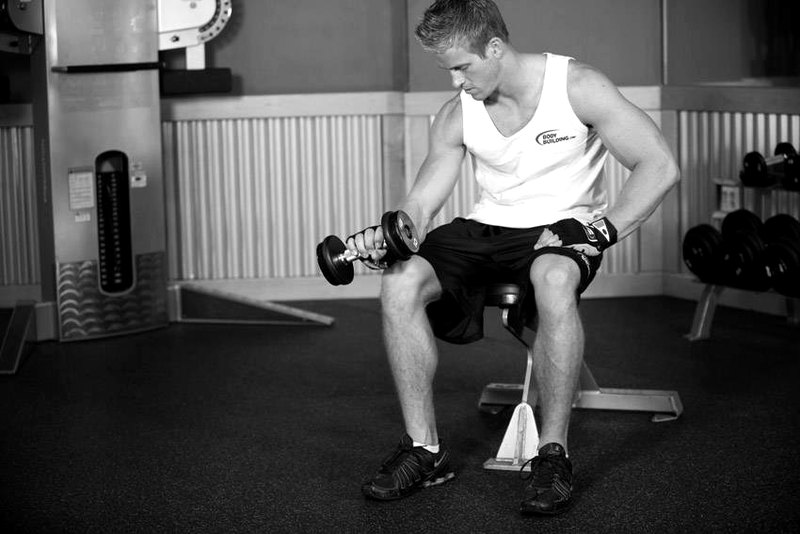 Seated One-Arm Dumbbell Palms-Down Wrist Curl — end position demonstration photo