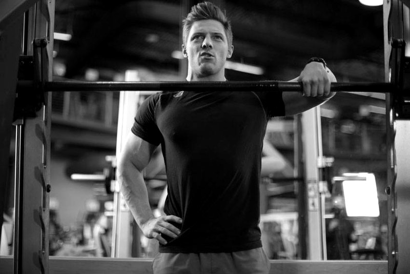 Smith Machine One-Arm Upright Row — end position demonstration photo
