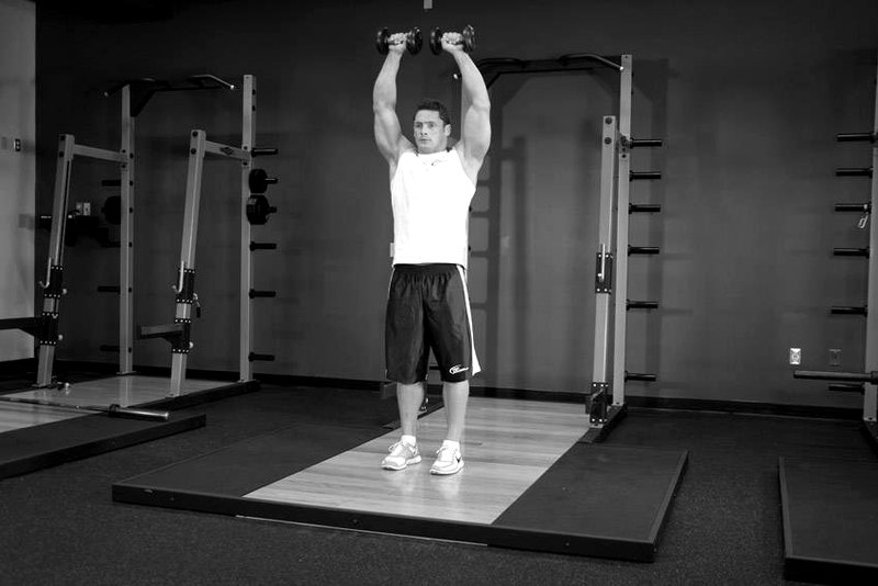 Standing Dumbbell Straight-Arm Front Delt Raise Above Head — end position demonstration photo