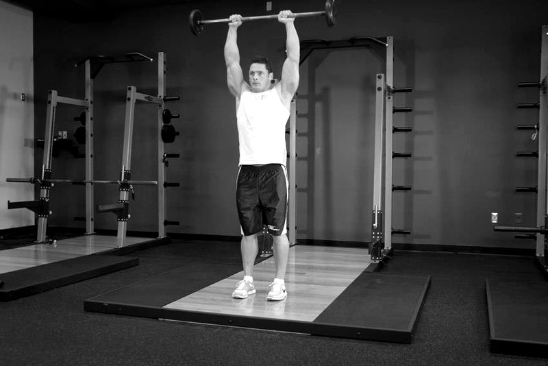 Standing Front Barbell Raise Over Head — end position demonstration photo