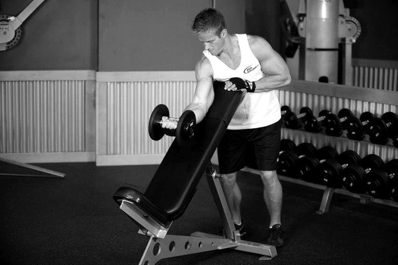 Standing One-Arm Dumbbell Curl Over Incline Bench — start position demonstration photo