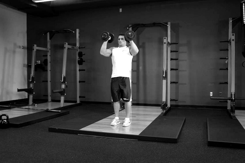 Standing Palms-In Dumbbell Press — end position demonstration photo