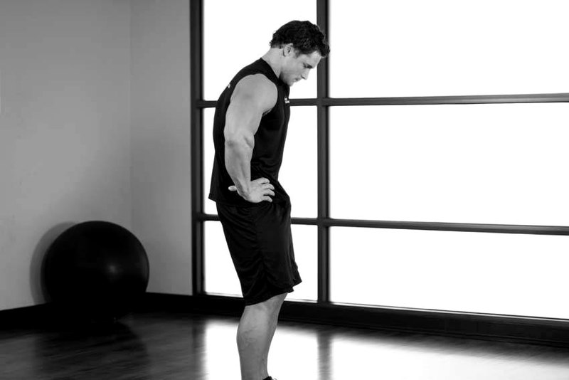 Standing Pelvic Tilt — end position demonstration photo