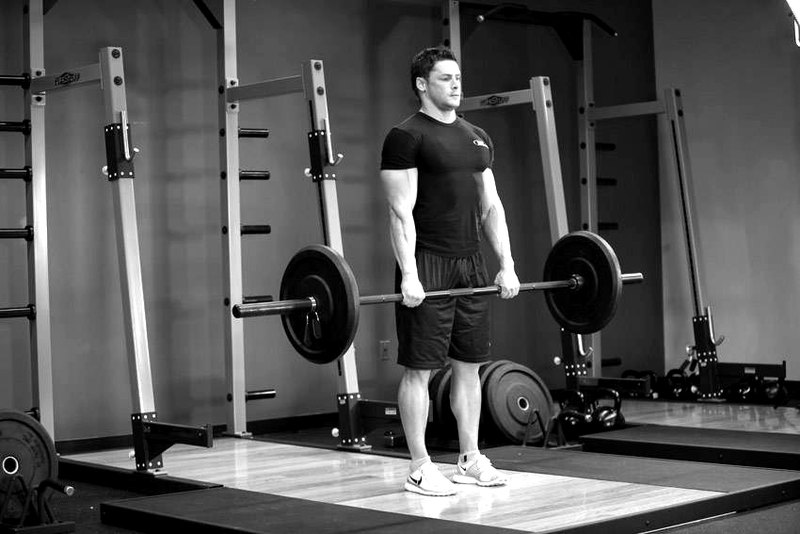 Stiff-Legged Barbell Deadlift — end position demonstration photo